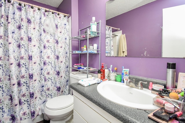 full bathroom featuring vanity, curtained shower, toilet, and a textured ceiling