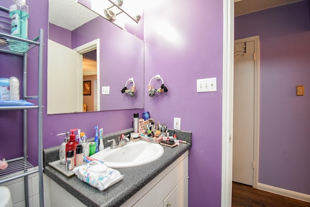 bathroom with vanity, baseboards, and wood finished floors