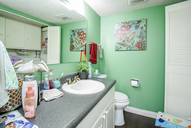 bathroom with vanity, a textured ceiling, baseboards, and wood finished floors
