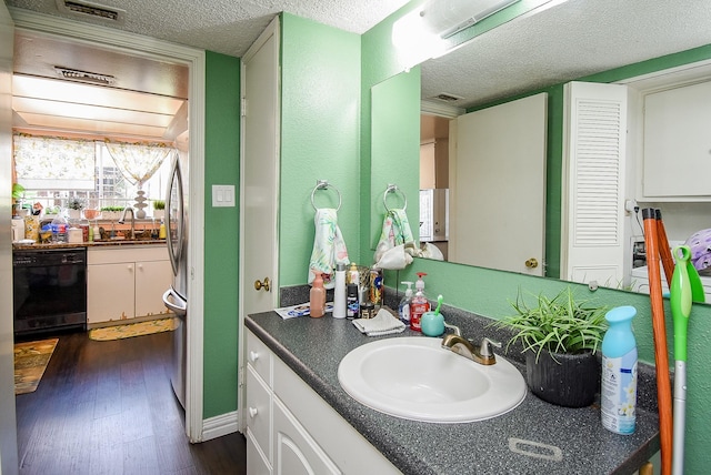 bathroom featuring visible vents, a textured ceiling, wood finished floors, and vanity