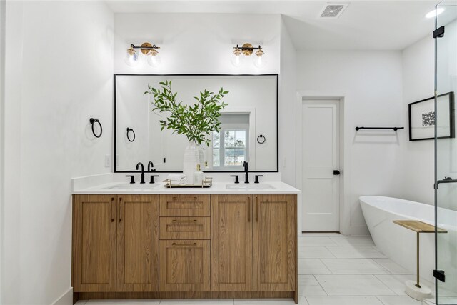 bathroom with double vanity, a soaking tub, visible vents, and a sink