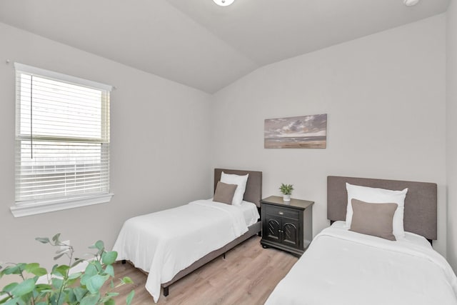 bedroom featuring light wood-type flooring and lofted ceiling