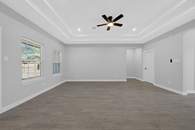 empty room featuring a raised ceiling, baseboards, a ceiling fan, and recessed lighting