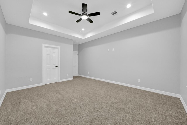 spare room with carpet floors, recessed lighting, a ceiling fan, baseboards, and a tray ceiling