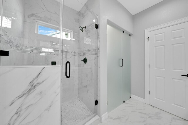 bathroom with baseboards, a marble finish shower, and marble finish floor