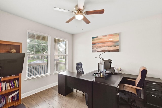 office area with a ceiling fan, baseboards, and wood finished floors