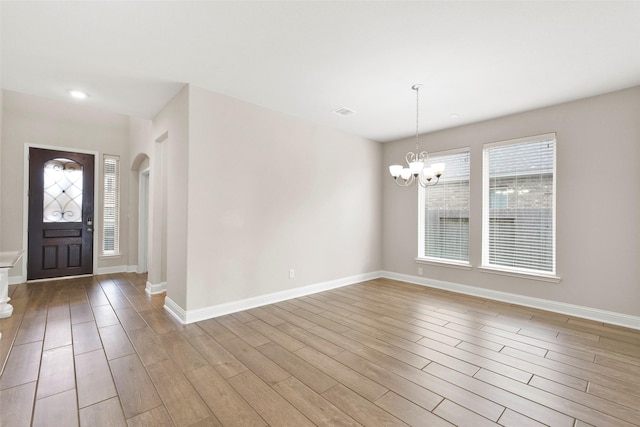 entryway with an inviting chandelier, baseboards, and wood finished floors