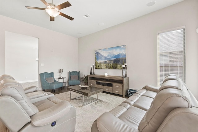 living area with ceiling fan, visible vents, and wood finished floors