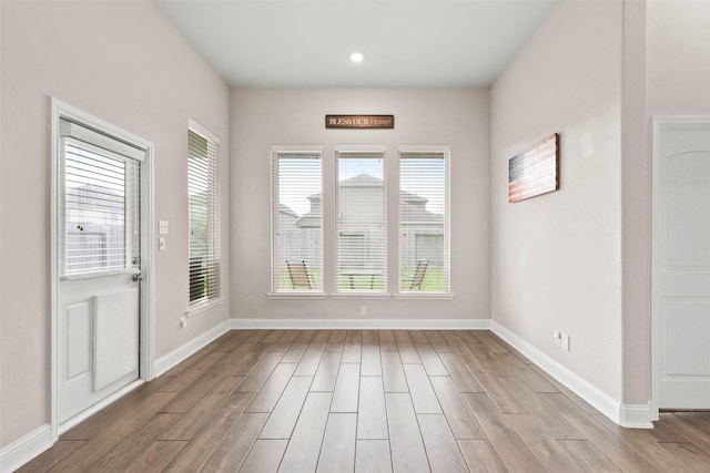 interior space with baseboards, recessed lighting, and wood finished floors