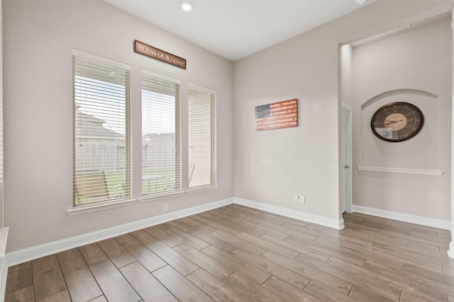 spare room featuring baseboards, recessed lighting, and wood finished floors