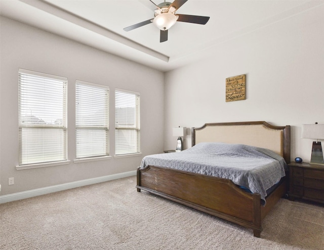 carpeted bedroom featuring baseboards and a ceiling fan