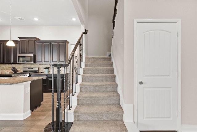 stairs featuring recessed lighting, visible vents, and wood finished floors