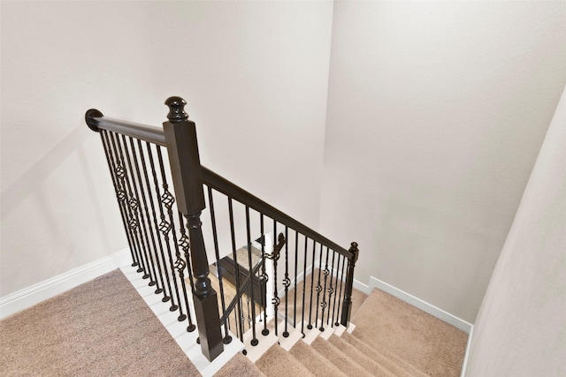 stairway featuring carpet floors and baseboards