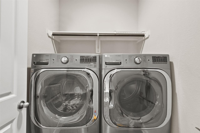 washroom featuring laundry area and washing machine and dryer