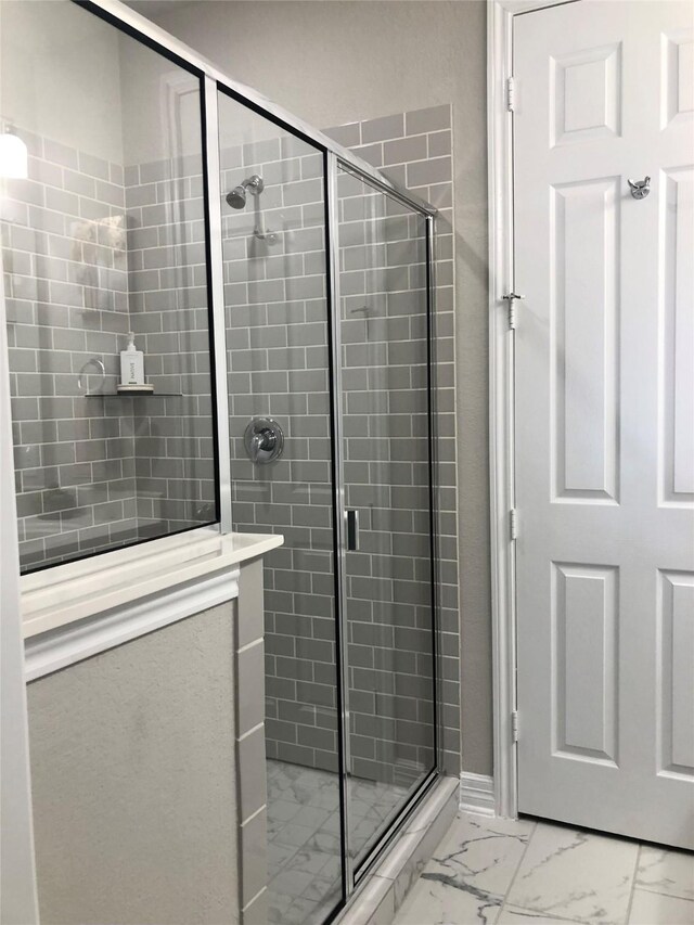 full bathroom with a stall shower and marble finish floor