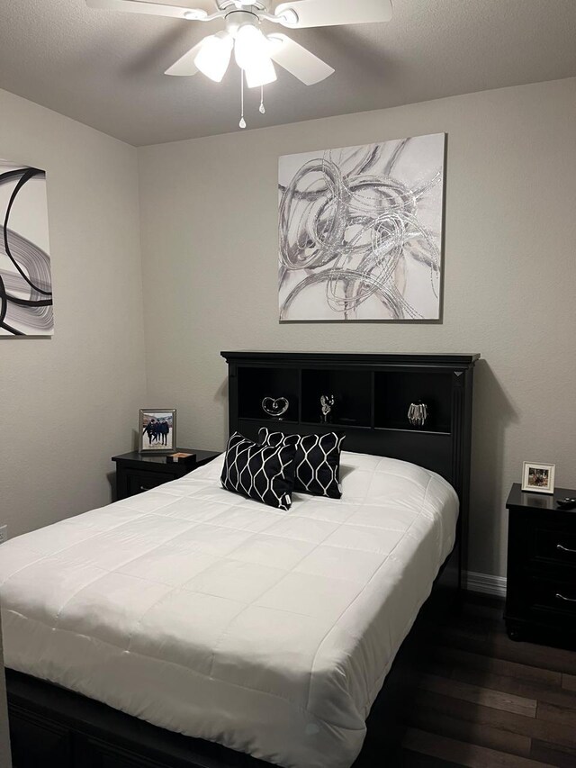 bedroom with baseboards, a ceiling fan, and dark wood finished floors
