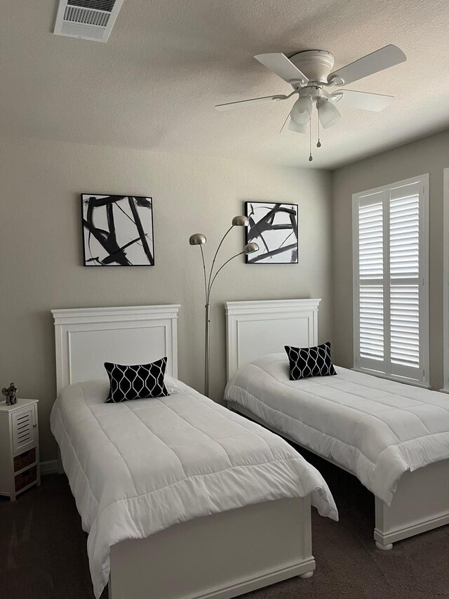 carpeted bedroom with ceiling fan and visible vents
