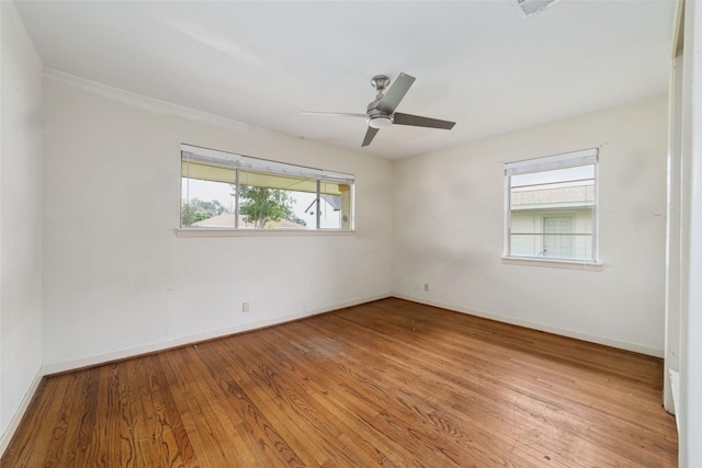 spare room with baseboards, wood-type flooring, a ceiling fan, and visible vents