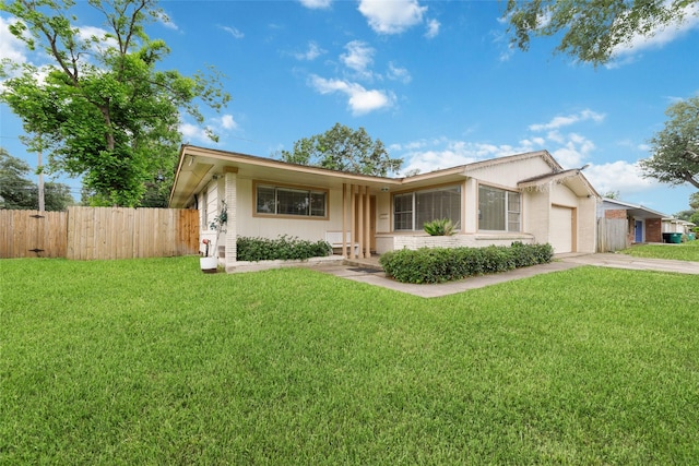 single story home with driveway, a front yard, brick siding, fence, and an attached garage