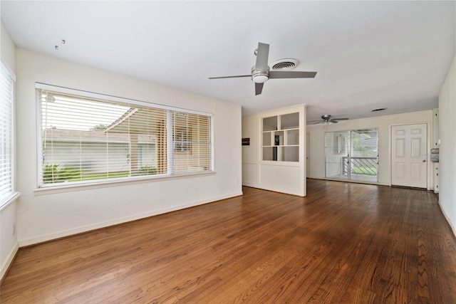 unfurnished living room with baseboards, a ceiling fan, wood finished floors, and a healthy amount of sunlight