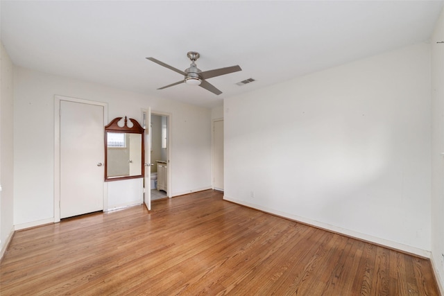 spare room with light wood-style floors, baseboards, ceiling fan, and visible vents