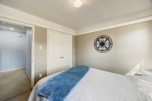 carpeted bedroom with a closet, baseboards, and attic access