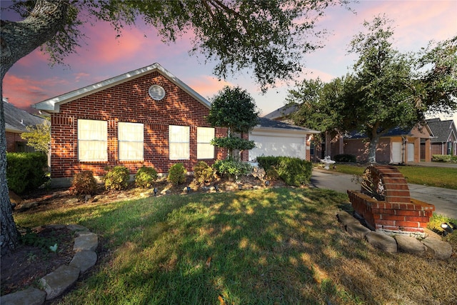 single story home featuring brick siding, driveway, and a front lawn