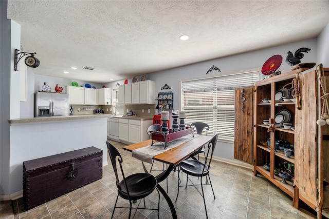 dining area with baseboards, recessed lighting, a textured ceiling, and a healthy amount of sunlight