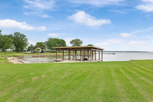 dock area with a water view and a yard