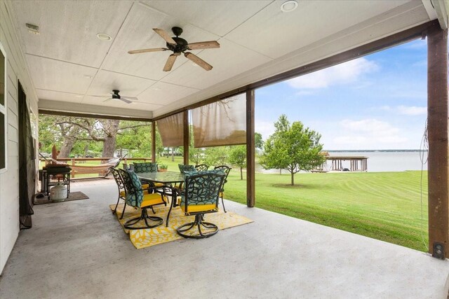 view of patio / terrace with outdoor dining area, a water view, and ceiling fan