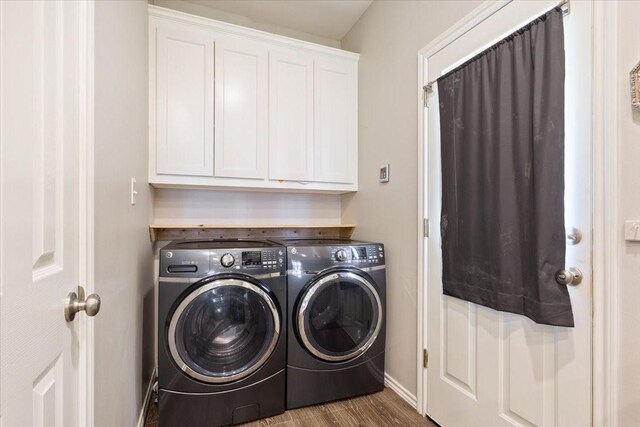 clothes washing area with baseboards, cabinet space, wood finished floors, and washing machine and clothes dryer
