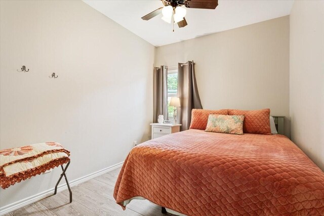 bedroom featuring light wood-style floors, baseboards, and ceiling fan