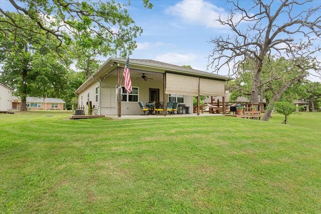 rear view of house with a yard, a patio, and ceiling fan