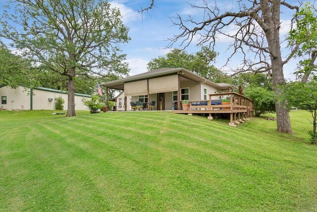 rear view of house with a lawn and a wooden deck