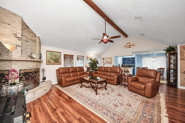 living area featuring visible vents, a brick fireplace, wood finished floors, ceiling fan, and lofted ceiling with beams