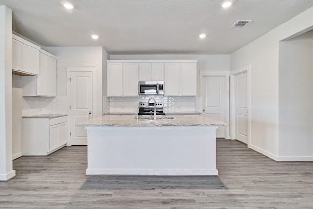 4660 Peony Green Dr, Katy, TX 77493 - kitchen with tasteful backsplash, a kitchen island with sink, stainless steel appliances, and visible vents