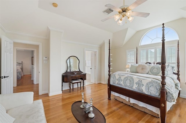 bedroom featuring light wood-style floors, baseboards, vaulted ceiling, visible vents, and ornamental molding