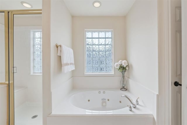 full bath featuring a whirlpool tub and a stall shower