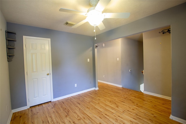 unfurnished room with visible vents, light wood-style flooring, ceiling fan, and baseboards