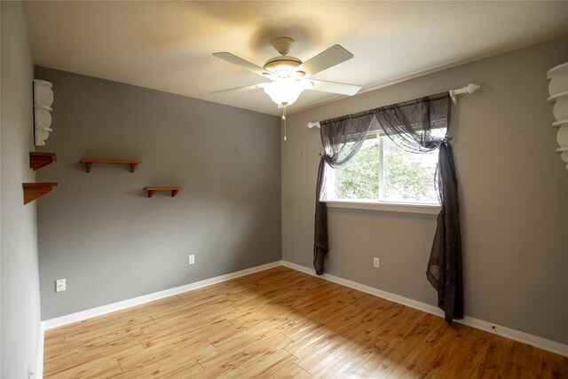 unfurnished room featuring baseboards, a ceiling fan, and wood finished floors