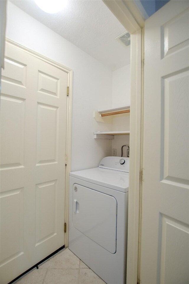 clothes washing area featuring laundry area, washer / clothes dryer, light tile patterned floors, and visible vents