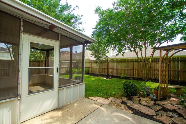 view of yard featuring a patio, a fenced backyard, and a sunroom