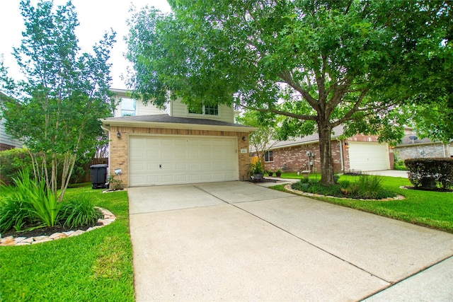 view of property hidden behind natural elements with an attached garage, driveway, a front lawn, and brick siding