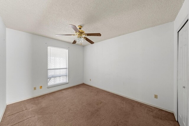 spare room featuring a textured ceiling, carpet, and ceiling fan