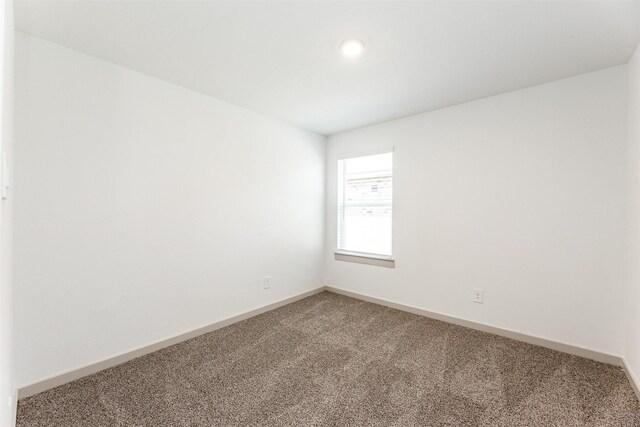 carpeted empty room featuring baseboards