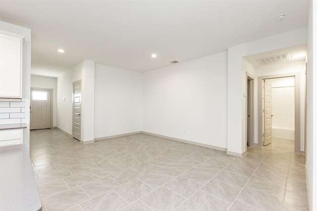 unfurnished room featuring recessed lighting, baseboards, visible vents, and light tile patterned floors