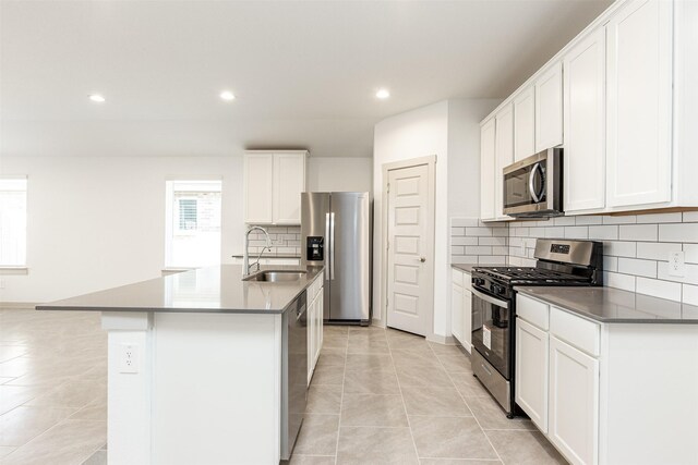 kitchen with a sink, a kitchen island with sink, stainless steel appliances, and recessed lighting