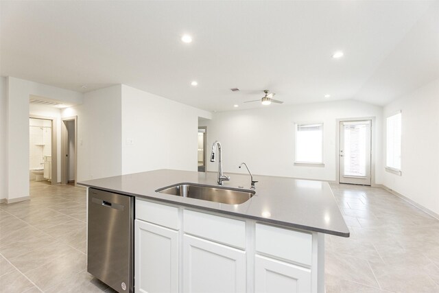 kitchen featuring stainless steel dishwasher, light tile patterned flooring, ceiling fan, a center island with sink, and a sink