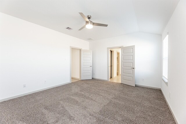 unfurnished bedroom featuring visible vents, baseboards, vaulted ceiling, and light carpet