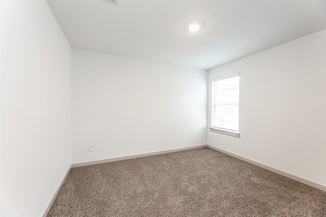 unfurnished room with carpet floors and baseboards